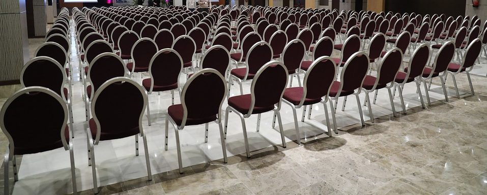 A large empty hall with all the chairs set out for a convention