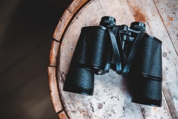 binoculars on a wooden table.