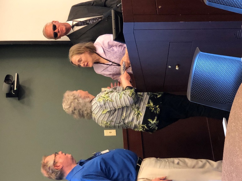 Mary Stip presenting the Friend of NDAB Award to Karla Peterson. Doug Stip and banquet emcee Vince Ulstad are in the background.
