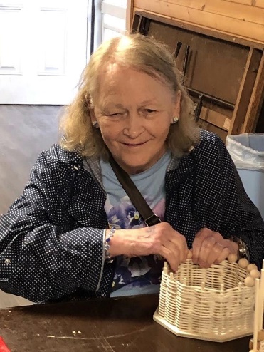 Loris is practicing her basket weaving skills at camp.